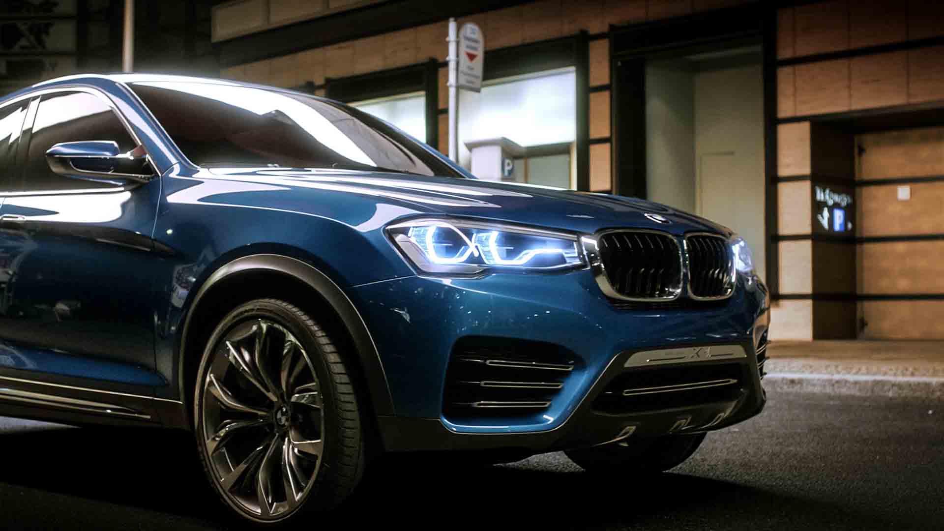 Das Bild zeigt einen blauen BMW. Es ist die Marke Concept X4. Er fährt auf einer Straße von links in das Bild. Hinter ihm sieht man eine Bushaltestelle. Das Bild dient als Sliderbild für den Portfolioeintrag BMW Concept X4 von Panda Pictures.